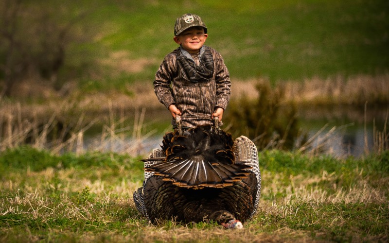 Cash standing behind a dead turkey